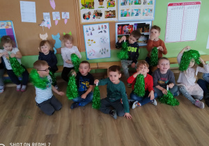 Dzieci trzymające zielone, imprezowe pompony